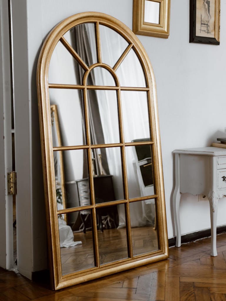 Beautiful arched mirror with wooden frame adding elegance to a classic interior space.